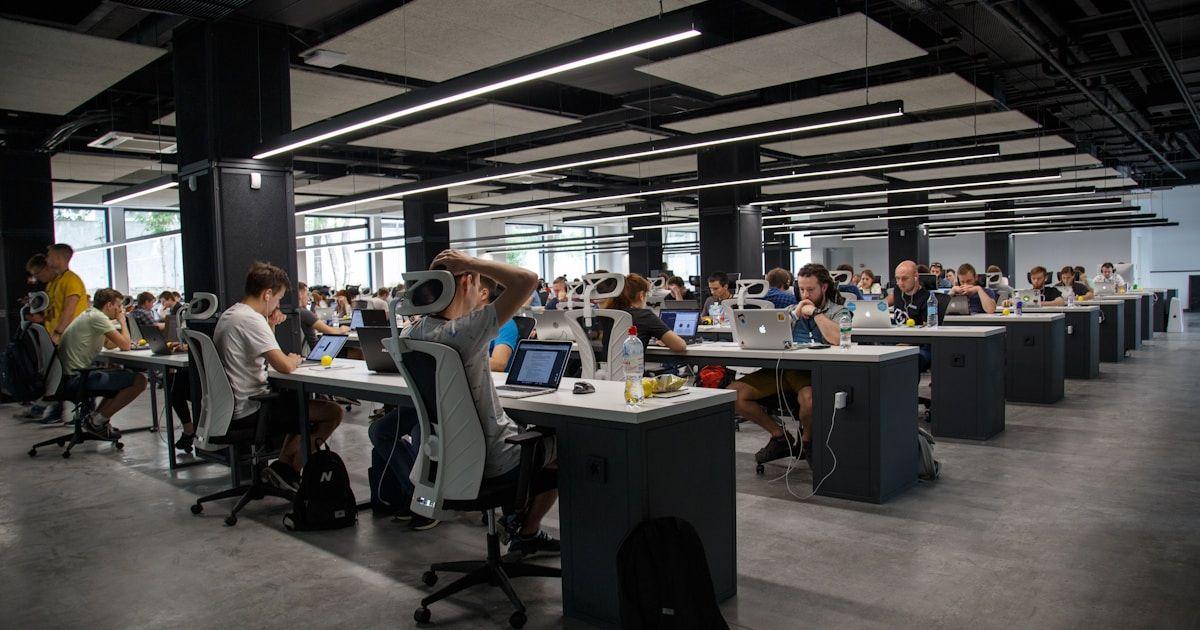 Modern office with team members working at computers in a collaborative technology workspace